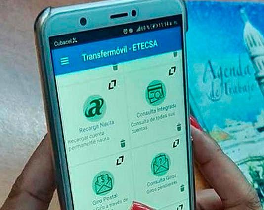 Persona con teléfono celular viendo la aplicación Transfermóvil 